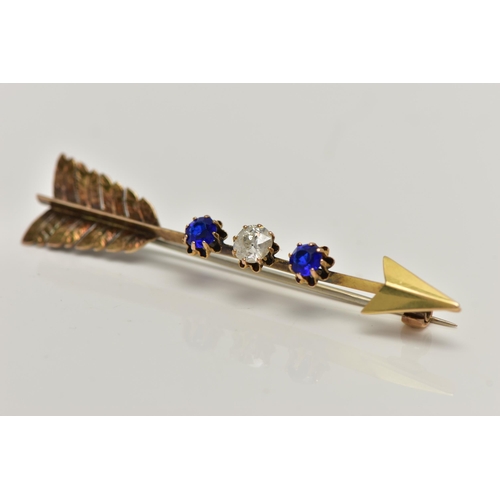 5 - A YELLOW METAL GEM SET ARROW BROOCH, polished arrow brooch with textured feathers, set with an old c... 