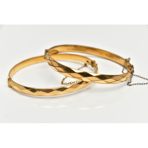 79 - TWO YELLOW METAL BANGLES, the first a hinged bangle with a faceted design, stamped 'gold metal core'... 