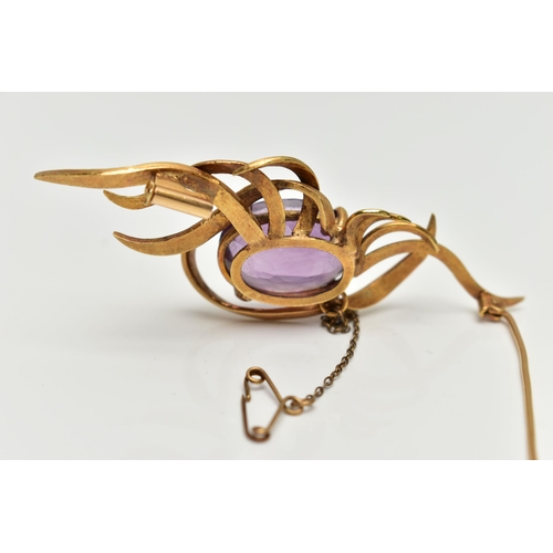 1 - A YELLOW METAL AMETHYST SPRAY BROOCH, designed with a four claw set, oval cut amethyst, within a spr... 