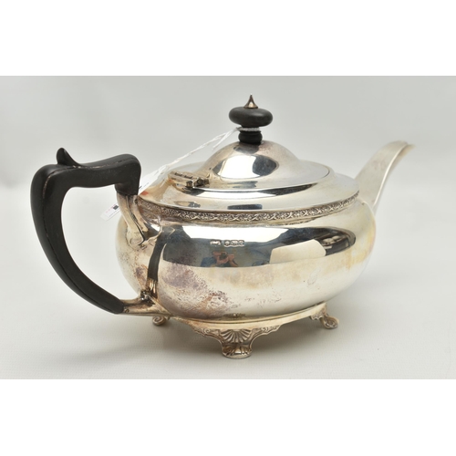 231 - A GEORGE V SILVER TEA POT OF SHAPED OVAL FORM, ebonised fitments, foliate cast rim and feet, makers ... 