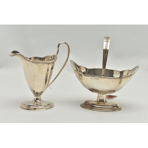 232 - AN EDWARDIAN MATCHED MILK JUG AND SWING HANDLED SUGAR BASKET OF PANELLED OVAL FORM, reeded rims, sho... 