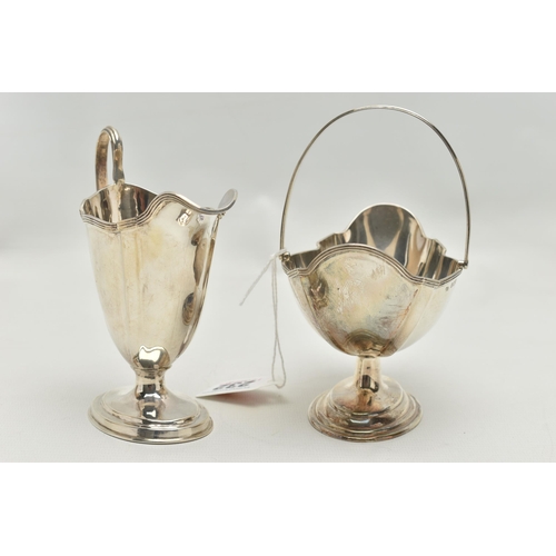 232 - AN EDWARDIAN MATCHED MILK JUG AND SWING HANDLED SUGAR BASKET OF PANELLED OVAL FORM, reeded rims, sho... 