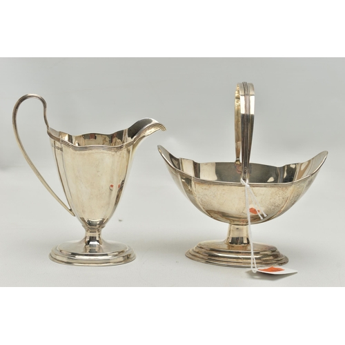 232 - AN EDWARDIAN MATCHED MILK JUG AND SWING HANDLED SUGAR BASKET OF PANELLED OVAL FORM, reeded rims, sho... 