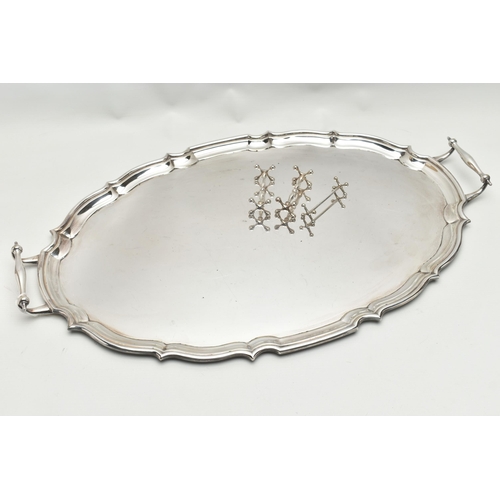 253 - AN EPNS TWIN HANDLED TRAY OF WAVY OVAL FORM AND THREE PLATED KNIFE RESTS, the tray with scrolled ove... 