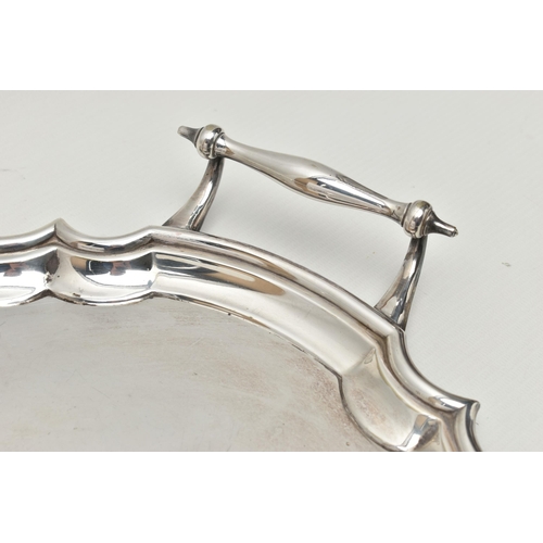 253 - AN EPNS TWIN HANDLED TRAY OF WAVY OVAL FORM AND THREE PLATED KNIFE RESTS, the tray with scrolled ove... 