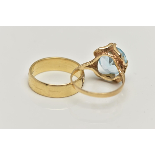 27 - TWO 9CT GOLD RINGS, the first designed with a double four claw set, oval cut light blue topaz, in an... 