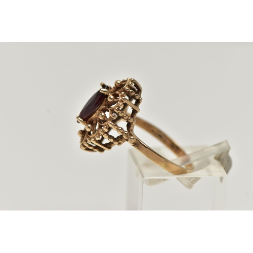 39 - A 9CT GOLD GARNET RING, of an openwork marquise outline, set to the centre with a marquise cut garne... 