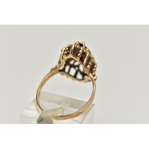 39 - A 9CT GOLD GARNET RING, of an openwork marquise outline, set to the centre with a marquise cut garne... 