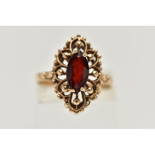 39 - A 9CT GOLD GARNET RING, of an openwork marquise outline, set to the centre with a marquise cut garne... 