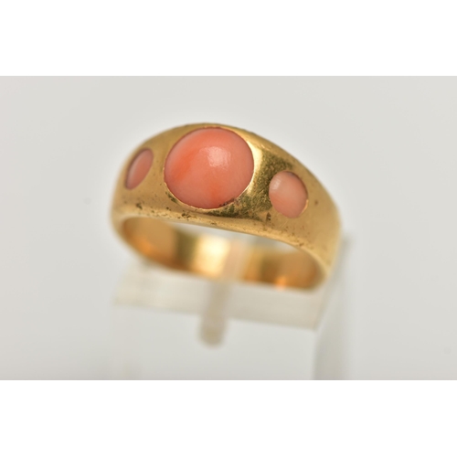 4 - A YELLOW METAL CORAL RING, designed with three circular cut coral cabochon inlayed to a yellow metal... 