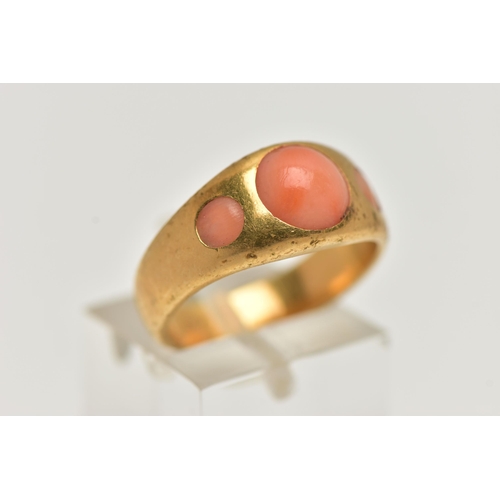 4 - A YELLOW METAL CORAL RING, designed with three circular cut coral cabochon inlayed to a yellow metal... 