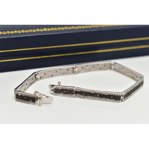 69 - A 9CT GOLD DIAMOND BRACELET, a white gold line bracelet comprised of eight panels, detailed with a c... 