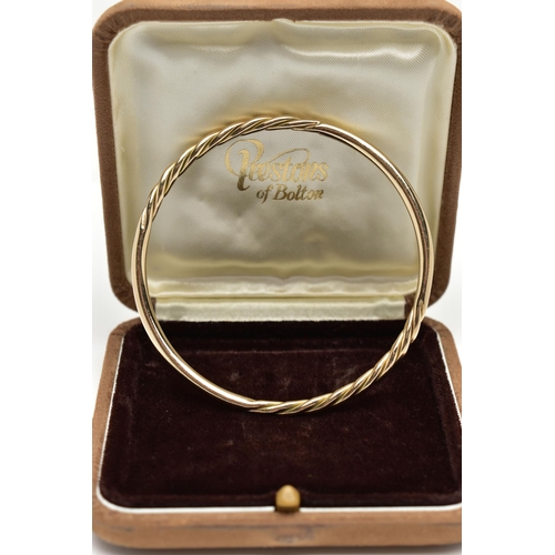 7 - A 9CT YELLOW GOLD BANGLE, twist and polished bangle, hallmarked 9ct Birmingham, approximate internal... 