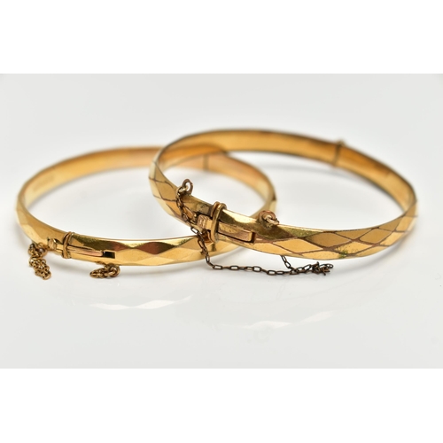 79 - TWO YELLOW METAL BANGLES, the first a hinged bangle with a faceted design, stamped 'gold metal core'... 