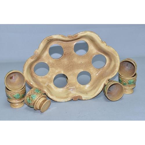 351 - A NINETEENTH CENTURY MAJOLICA STAND CONTAINING SIX EGG CUPS, the stand of lobed form with twisting h... 