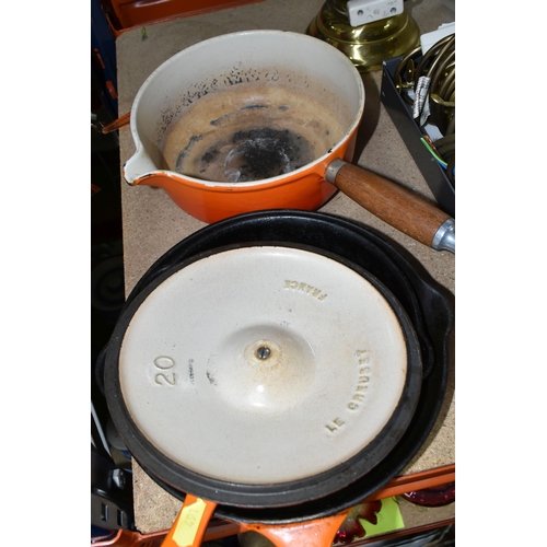 491 - THREE LE CREUSET PANS, in orange, comprising a covered saucepan with pouring spout, diameter 20cm, a... 