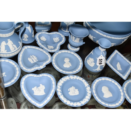 516 - A COLLECTION OF WEDGWOOD BLUE JASPERWARE, comprising two bud vases, a jug (soft padding stuck to bas... 