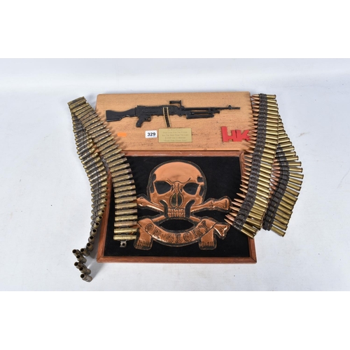 329 - A LARGE DEATH OR GLORY BADGE, a miniature automatic rifle mounted onto a board and two belts of iner... 