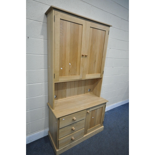 1241 - A LIGHT OAK DRESSER, top section with double panelled doors, over a base with three drawers, beside ... 