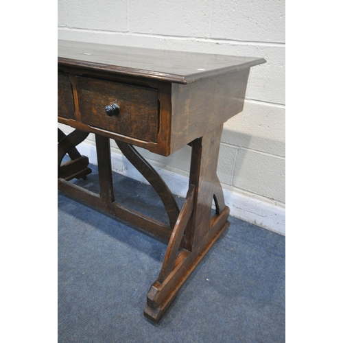 1263 - AN ARTS AND CRAFTS OAK TRESTLE SIDE TABLE, with three drawers, on a shaped base united by a shaped s... 