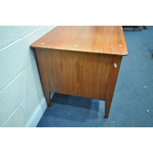 1309 - IN THE MANNER OF GORDON RUSSELL, a mid-century teak desk, with a single cupboard door, and three dra... 