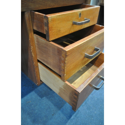 1309 - IN THE MANNER OF GORDON RUSSELL, a mid-century teak desk, with a single cupboard door, and three dra... 