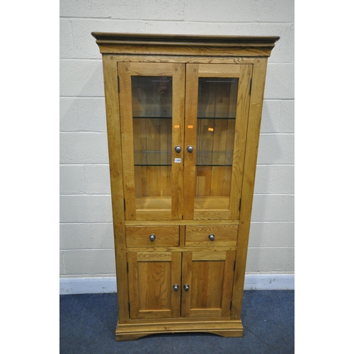 1330 - A SOLID OAK GLAZED CABINET, with two glass shelves and a two drawers over two cupboard doors, width ... 