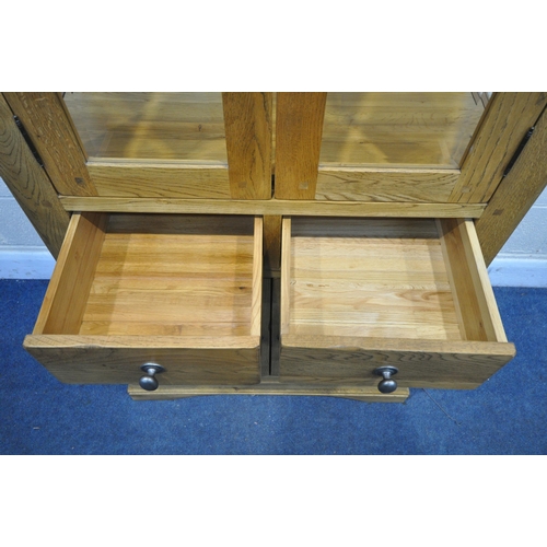 1330 - A SOLID OAK GLAZED CABINET, with two glass shelves and a two drawers over two cupboard doors, width ... 