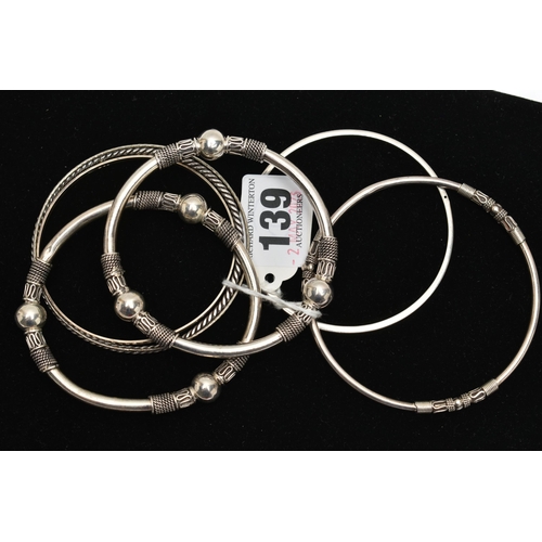 139 - SEVEN WHITE METAL BANGLES, to include two with bead and rope twist patterns, unmarked, a thin bangle... 