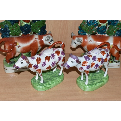 378 - FOUR PIECES OF COW THEMED POTTERY, comprising two cow creamers with red and pink lustre patches, sta... 