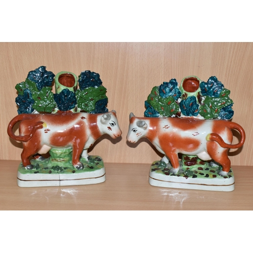 378 - FOUR PIECES OF COW THEMED POTTERY, comprising two cow creamers with red and pink lustre patches, sta... 