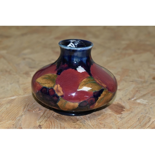 453 - A MOORCROFT POTTERY 'POMEGRANATE' VASE, of squat form, tube lined Pomegranate pattern on a navy blue... 