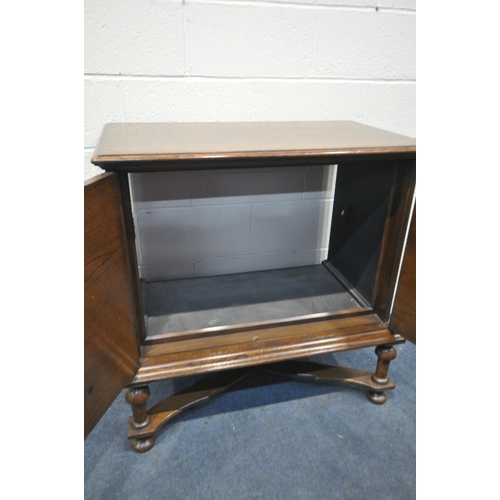 1192 - A JACOBEAN STYLE OAK TWO DOOR TV CABINET, on turned legs, united by a stretcher, width 91cm x depth ... 