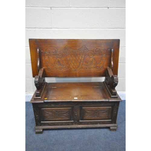 1235 - A 20TH CENTURY MONKS BENCH, lifting lid supported by lion mask uprights, surrounding storage compart... 