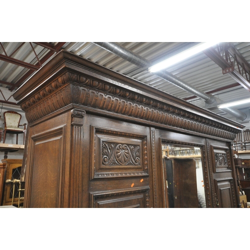 1334 - AN EARLY 20TH CENTURY HAMPTON AND SONS OF PALL MALL EAST LONDON, CARVED OAK COMPACTUM WARDROBE, comp... 