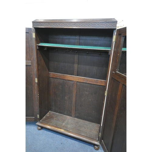 1335 - AN EARLY 20TH CENTURY MAPLE AND CO OF LONDON, OAK TWO DOOR HALL ROBE/CUPBOARD, enclosing a shelf fit... 