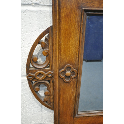 1384 - AN EARLY 20TH CENTURY OAK FRAMED RECTANGULAR WALL MIRROR, with a half circle foliate open fretwork d... 