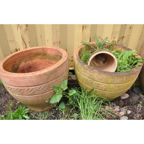 1004 - A SELECTION OF WEATHERED TERRACOTTA POTS comprising three circular terracotta pots and a smaller pla... 