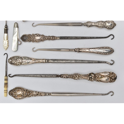 217 - TWELVE SILVER HANDLED BUTTON HOOKS AND SHOE HORNS, together with six mother of pearl handled needlew... 