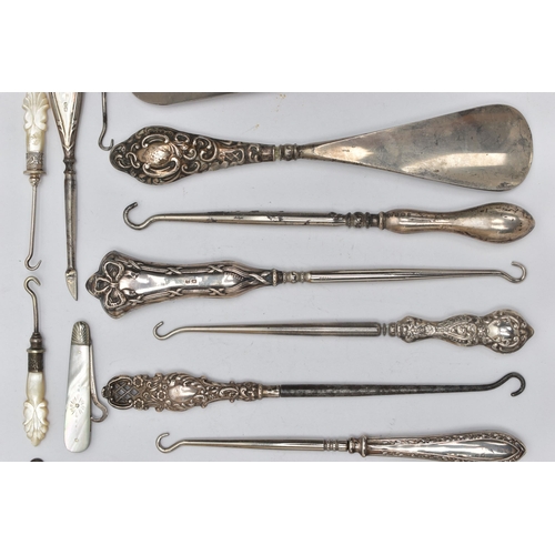 217 - TWELVE SILVER HANDLED BUTTON HOOKS AND SHOE HORNS, together with six mother of pearl handled needlew... 