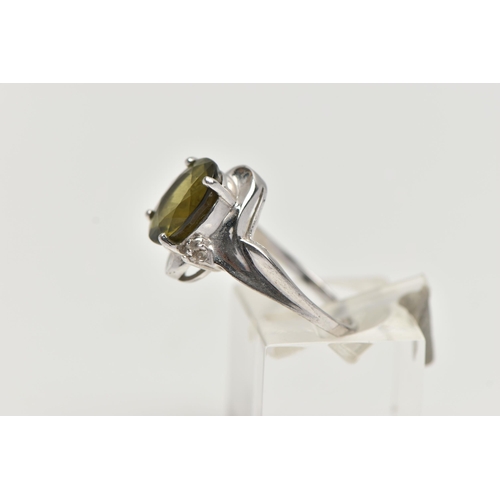 44 - A 9CT WHITE GOLD, TOURMALINE AND DIAMOND RING, designed with an oval cut green tourmaline in a four ... 