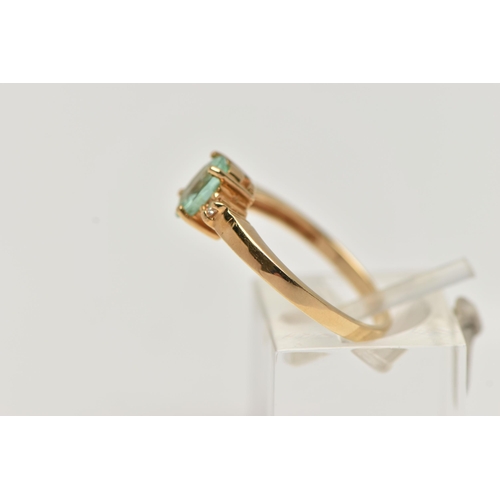 92 - A GEM SET RING, designed as a central oval light green stone assessed as tourmaline, flanked by bril... 