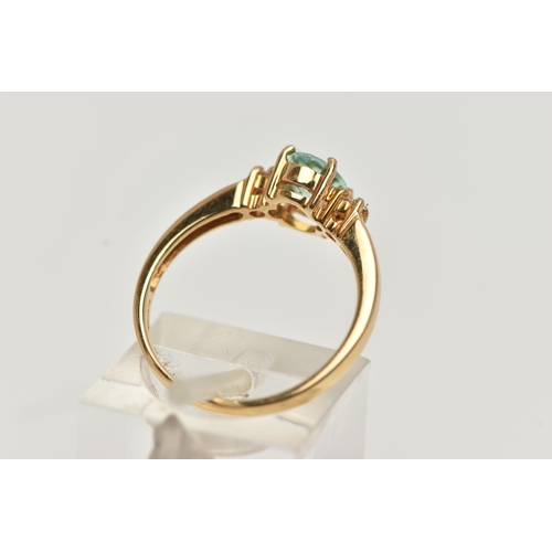 92 - A GEM SET RING, designed as a central oval light green stone assessed as tourmaline, flanked by bril... 