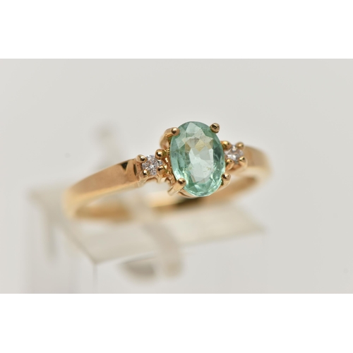 92 - A GEM SET RING, designed as a central oval light green stone assessed as tourmaline, flanked by bril... 