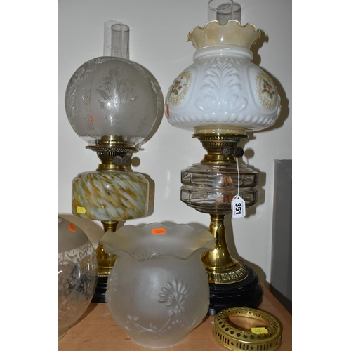 351 - THREE OIL LAMPS AND A SELECTION OF SHADES, the oil lamps all having glass reservoirs - one with gree... 