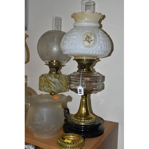 351 - THREE OIL LAMPS AND A SELECTION OF SHADES, the oil lamps all having glass reservoirs - one with gree... 