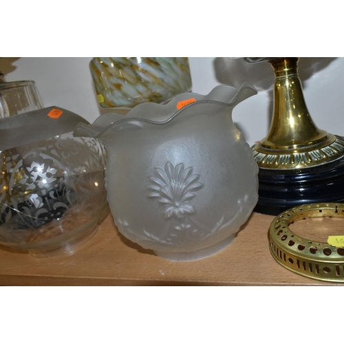 351 - THREE OIL LAMPS AND A SELECTION OF SHADES, the oil lamps all having glass reservoirs - one with gree... 