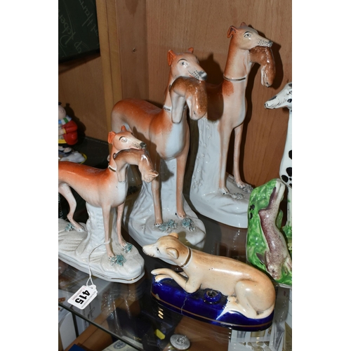 415 - FOUR VICTORIAN STAFFORDSHIRE POTTERY FIGURES OF DOGS STANDING WITH HARES AND A PEN HOLDER, three of ... 