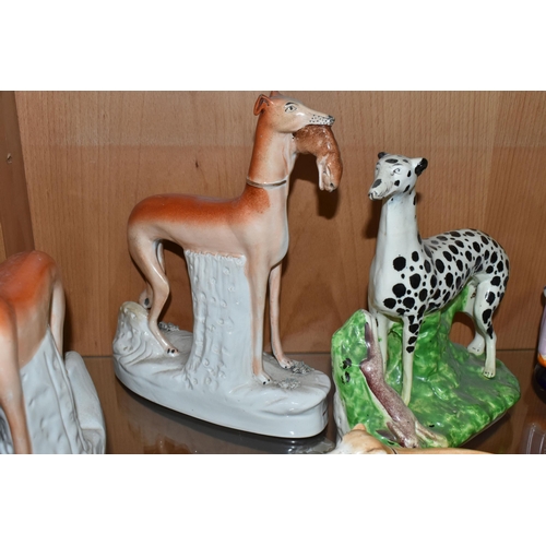 415 - FOUR VICTORIAN STAFFORDSHIRE POTTERY FIGURES OF DOGS STANDING WITH HARES AND A PEN HOLDER, three of ... 