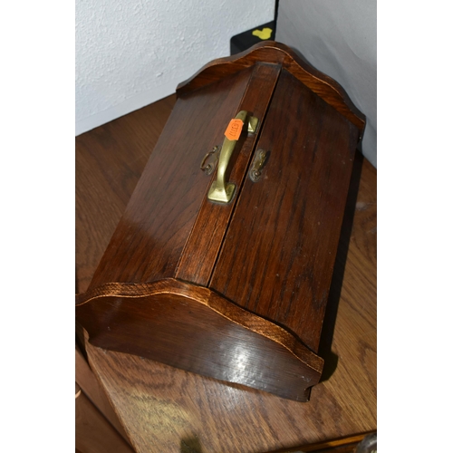 462 - AN EDWARDIAN OAK TANTULUS, with three decanters, original stoppers (one chipped at base), locking me... 